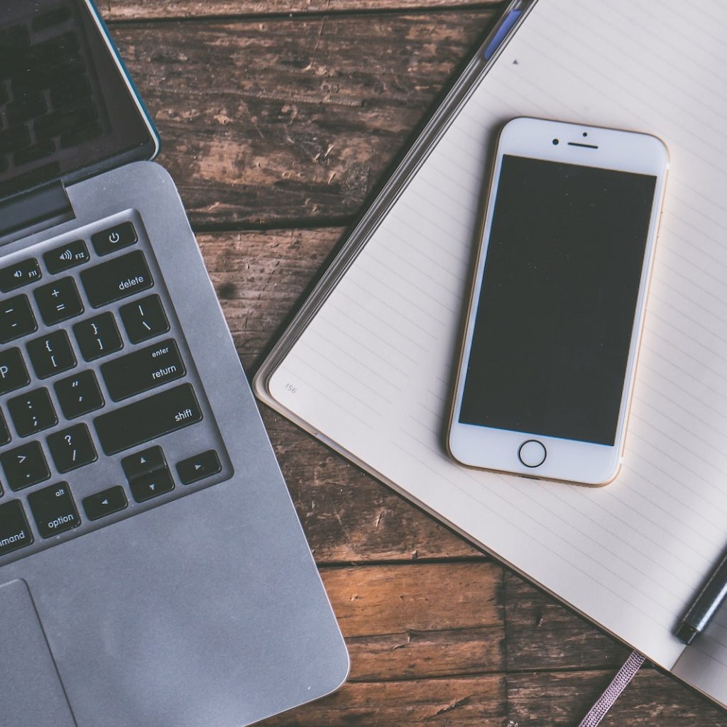 Flat Lay Photography of Gold Iphone on Opened Notebook Beside Pen